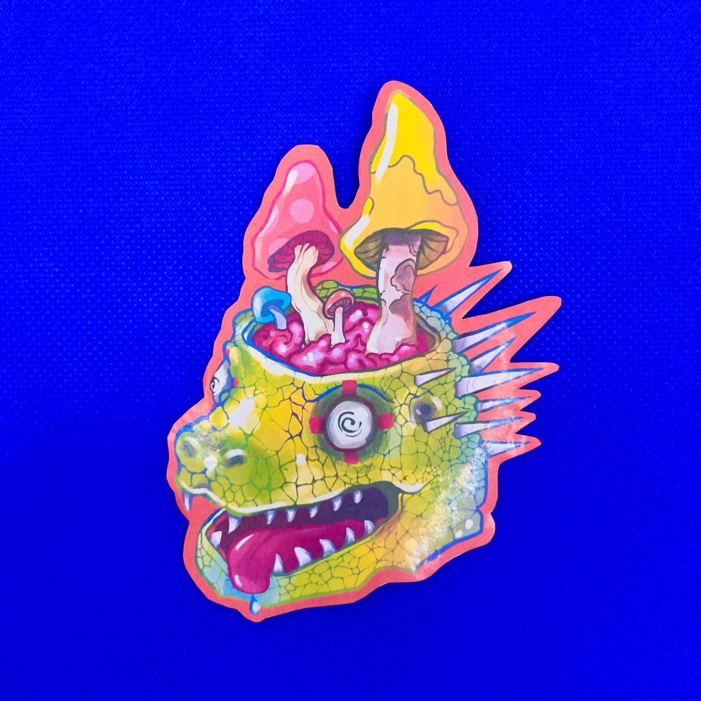 A colorful sticker or decal featuring a stylized green dragon head with mushrooms growing out of its mouth, set against a solid bright blue background.